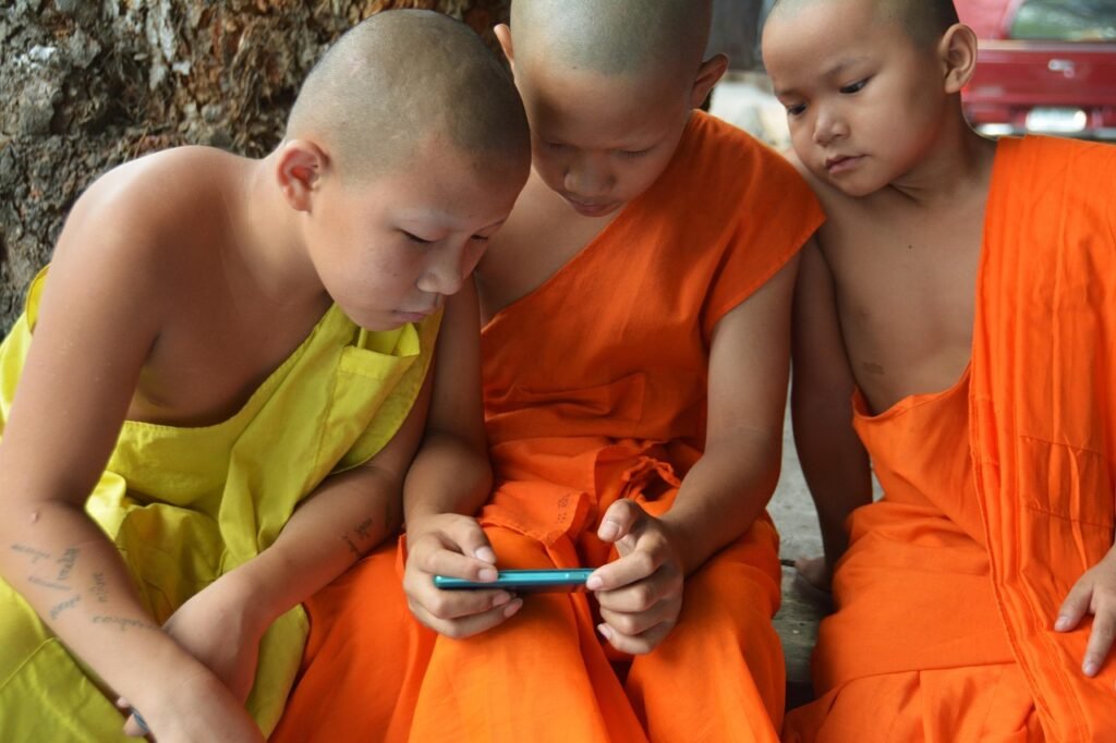 children learning, video game, boys, novices, monks, thailand, orange, young, buddhist, little, tradition, culture, temple, eastern, child, monk, kid, male, religious, travel, buddhism, monastery, traditional, religion, interest, phone, brown video, brown phone, brown learning, brown videos, brown telephone