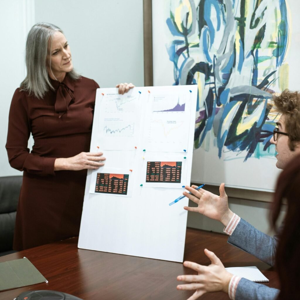 Business professionals discussing graphs during a meeting presentation in a modern conference room.