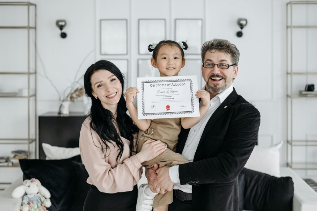 Happy multicultural family celebrating adoption with certificate indoors.